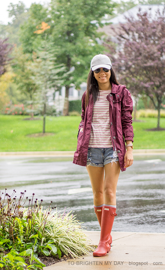 gray baseball cap, burgundy jacket, pink striped top, distressed shorts, oversized watch, red rain boots