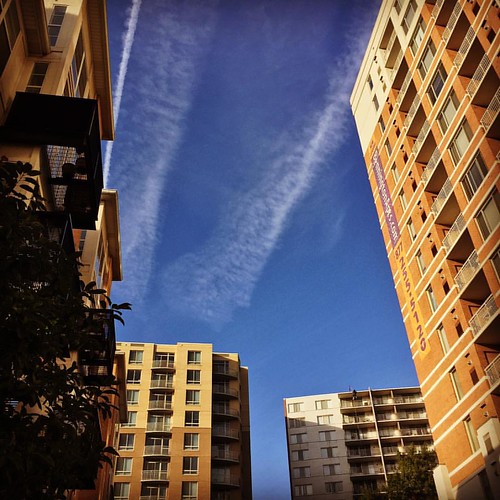I like how the buildings frame the sky this morning (clouds, contrails).