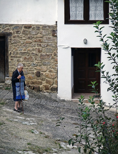 An old lady makes her way down the steep streets of a village in the Picos de Europa, Spain