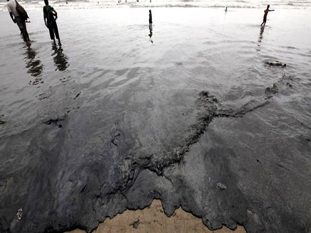 मुम्बई के समुद्र तट पर बिखरा पड़ा तेल की मोटी परत