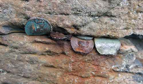 Coins jammed into he striking hexagonal basalt rock formations of Giant's Causeway in Northern Ireland, UK